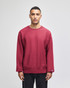 A red Champion Reverse Weave® adult crew sweatshirt on a model, featuring a logo.