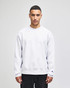 A light grey sweatshirt featuring a crew neckline and long sleeves, with a logo on the sleeve.