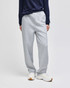 Light grey open-bottom fleece pants with pockets, featuring a relaxed fit and worn with a navy top and white shoes.