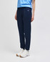 Adult fleece jogger in navy, featuring an elasticated waistband and a logo, styled with a light blue top and sneakers.