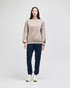 A model wears a beige Champion Powerblend® adult crewneck sweatshirt paired with navy trousers and white sneakers.