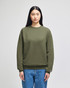 A green Champion Powerblend® adult crewneck sweatshirt displayed on a model, featuring a logo on the sleeve.