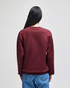 A burgundy crewneck sweatshirt from the back, featuring long sleeves and a relaxed fit. It has a small logo.
