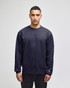 A navy blue crewneck sweatshirt with a logo on the sleeve, featuring a relaxed fit and long sleeves.