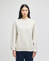 A cream-coloured adult crewneck sweatshirt with long sleeves and a logo on the sleeve.