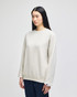 A light beige adult crewneck sweatshirt with a relaxed fit and a small logo.
