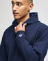 A navy blue full-zip hooded sweatshirt with a logo on the sleeve, featuring a relaxed fit and drawstring hood.