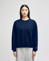 A navy blue women's crewneck sweatshirt with a relaxed fit and a branding logo on the sleeve.