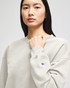 A grey Champion Powerblend® women's crewneck sweatshirt with a logo on the sleeve, worn by a model.