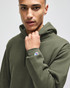 A green hooded sweatshirt with a fitted design and a small logo on the sleeve, worn by a model.