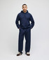 A navy pullover hooded sweatshirt paired with matching pants, featuring a logo on the sweatshirt.
