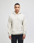 A light beige pullover hooded sweatshirt with a front pocket and a logo on the sleeve.