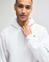 A white pullover hooded sweatshirt with a logo, worn by a person with short hair.