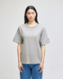 A grey Champion Adult Heritage Jersey T-Shirt on a model, featuring a relaxed fit and short sleeves.