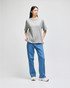 A grey Champion Adult Heritage Jersey T-Shirt worn with blue jeans, featuring a casual style and relaxed fit.