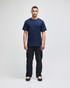 A navy blue Champion adult short-sleeve T-shirt displayed on a male model, paired with black pants.