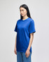 A blue Champion adult short-sleeve t-shirt with a logo, paired with blue jeans, displayed on a model.