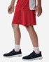 Men's Pro-Lock Performance Short in red, paired with dark sneakers and white socks. Features a visible logo on the shorts.
