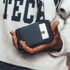 A hand holding a black and grey Thread Zipper Wallet, featuring a zippered compartment and a card slot.