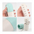 A capsule-shaped pill organiser in light blue and cream, featuring compartments labelled for each day of the week.