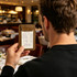 A person holding a brown Mini Bills Clipboard displaying a receipt, set in a restaurant environment.
