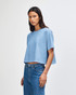 A blue heavyweight cotton women's crop boxy T-shirt with a loose fit, featuring a logo on the side.