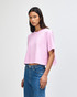 A pale pink women's crop boxy T-shirt, featuring a relaxed fit and short sleeves, worn with blue jeans.