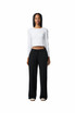 Wide leg pants in black worn with a fitted white long-sleeve top. Features a drawstring waist and a logo.