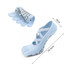 A pair of light blue yoga toe socks with a textured sole and a logo, laid out alongside a rolled sock.