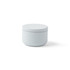A mini tin candle in a soft grey container with a smooth lid. The container has a round shape.