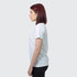 A side view of a woman wearing a white TRENDSWEAR Viva women's T-shirt. The shirt has a simple design and a logo.