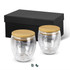 A drinkware set featuring two clear glass mugs with bamboo lids, presented in a black gift box.