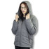 A woman wearing a grey puffer jacket with a hood, featuring a zip closure and side pockets.