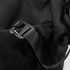 A close-up of a black duffle bag featuring a plastic buckle and strap, showcasing its durable fabric texture.
