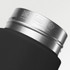 A drink bottle with a black body and a stainless steel lid, featuring a logo and care instructions.