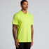 A man wearing a bright yellow polo shirt stands against a light background. The shirt has a logo on it.