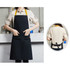 A poly-cotton canvas black bib apron with a yellow neck strap and front pockets. Includes a logo on the fabric.