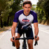 A cycling jersey featuring a white and purple design with raglan short sleeves, showcasing a logo on the front.