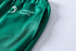 Green unisex adult sports shorts made from 100% polyester, featuring a side pocket and a logo.