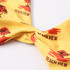A yellow bikini top with a tropical design featuring palm trees and a knot detail. It has a logo.