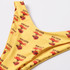 A yellow bikini bottom featuring a colourful beach-themed print and a logo. Made from polyester and spandex.