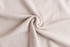 A close-up view of soft, beige fabric, featuring a smooth texture and a swirl pattern.