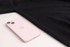A black unisex cotton turtleneck sweater laid flat beside a pink iPhone. The sweater features a logo.