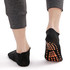 Low cut black gripper socks with an orange patterned sole, displayed on a person's feet.