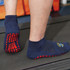 Crew Gripper Socks in navy blue with red grip patterns on the soles, displayed on a treadmill.