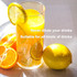 A glass of yellow drink with lemon slices and ice cubes. Includes fresh oranges and a lemon beside it.