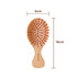 A small bamboo hairbrush featuring a wooden body and orange bristles, measuring 6cm by 14cm.