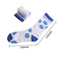 A pair of blue and white crew socks featuring a floral design, with one rolled up next to the other.