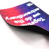 A rubber sponge mouse mat with a colourful geometric design and a logo, featuring a curved edge.