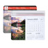 A mouse mat featuring a scenic landscape, including a lake, mountains, and a calendar for December 2024 to February 2025.